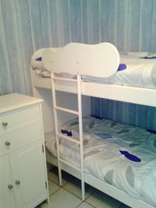 a childs bunk bed with a white chair in a room at Appartement cosy à Hendaye, 45 m², parking inclus in Hendaye