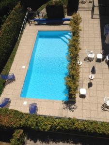 サン・ジェルヴェ・レ・バンにあるAppartement de 3 chambres a St Gervais les Bains a 400 m des pistes avec piscine partagee et balcon amenageのスイミングプール(椅子、パラソル付)のオーバーヘッドビュー