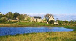 a castle on a hill next to a body of water at Hôtel de la baie de Paimpol in Ploubazlanec