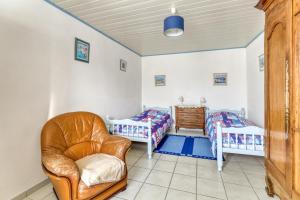 a living room with two twin beds and a chair at Maison de 2 chambres a L'Epine a 700 m de la plage avec jardin clos et wifi in LʼÉpine