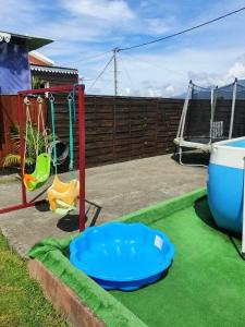 a play area with a swing and a playground at Villa de 3 chambres avec piscine privee jacuzzi et jardin clos a La Plaine des Cafres in La Plaine des Cafres