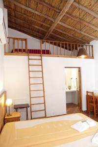 een kamer met een bed en een ladder aan de muur bij One bedroom house with shared pool furnished terrace and wifi at Castro Marim in Castro Marim