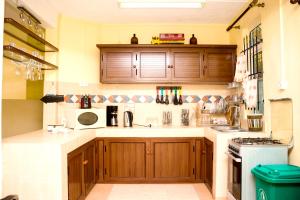 a large kitchen with wooden cabinets and a stove at Spacious apartment in Pereybere, 100 m² with shared pool in Pereybere