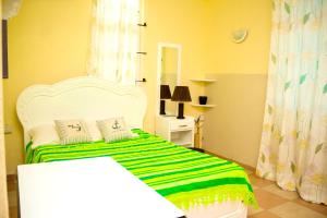 a bedroom with a bed with a green and white blanket at Spacious apartment in Pereybere, 100 m² with shared pool in Pereybere
