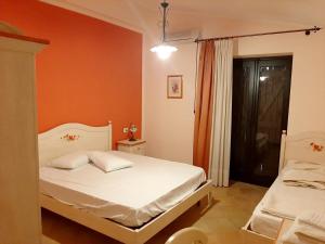 una camera con un letto bianco e una parete arancione di 5 bedrooms villa with private pool furnished garden and wifi at Bompensiere a Bompensiere