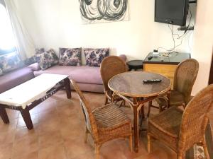 a living room with a couch and a table and chairs at Spacious apartment with terrace in Cabo Negro, 70 m² + Pool in Cabo Negro