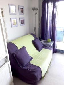 een slaapkamer met een groot bed met paarse kussens bij Appartement d'une chambre avec vue sur la mer terrasse amenagee et wifi a Theoule sur Mer in Théoule-sur-Mer