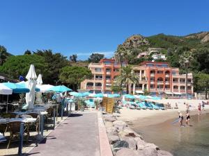 テウル・シュル・メールにあるAppartement confortable à Théoule-sur-Mer, 30 m², vue mer.のパラソルと水遊びをする人々がいるビーチ