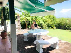 une table et deux bancs sur un patio dans l'établissement Maison de 4 chambres a Saint Francois a 300 m de la plage avec vue sur la mer piscine privee et jardin clos, à Saint-François