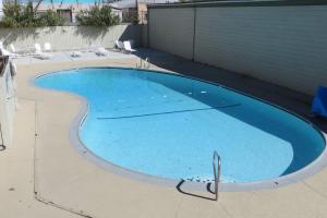 una piscina vacía con sillas alrededor en American Inn Stockton, en Stockton