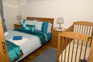 a bedroom with a crib and a bed with blue pillows at Charming house in Santa Cruz with sea view in Santa Cruz +20 photos