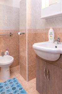 y baño con lavabo, aseo y espejo. en One bedroom apartement at Avola 200 m away from the beach with sea view furnished terrace and wifi, en Avola