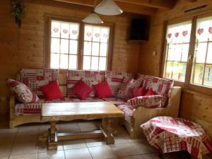 een woonkamer met een bank met rode kussens bij Chalet de 4 chambres avec jardin amenage a Lalaye in Lalaye
