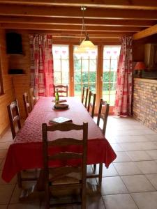 een eetkamer met een rode tafel en stoelen bij Chalet de 4 chambres avec jardin amenage a Lalaye in Lalaye