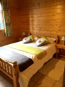 een slaapkamer met een bed in een blokhut bij Chalet de 4 chambres avec jardin amenage a Lalaye in Lalaye