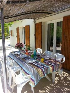 una mesa con sillas blancas y un mantel en ella en Villa de 4 chambres avec piscine privee et jardin clos a Le Beaucet, en Le Beaucet