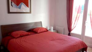 1 dormitorio con 1 cama roja y 2 almohadas rojas. en Villa de 4 chambres avec piscine privee et jardin clos a Le Beaucet, en Le Beaucet