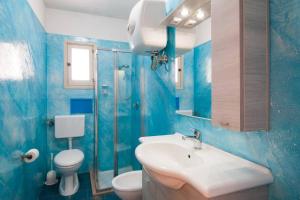 a blue bathroom with a sink and a toilet at Romantic Apartment in Vieste - 40 m² with Sea View in Vieste
