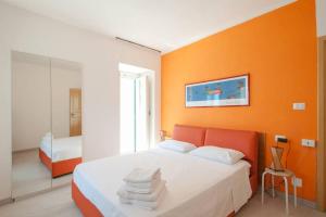 a bedroom with a bed with an orange wall at Romantic Apartment in Vieste - 40 m² with Sea View in Vieste +19 photos
