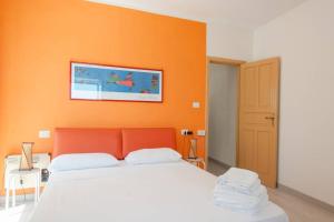 - une chambre dotée d'un lit avec un mur orange dans l'établissement One bedroom appartement at Vieste 500 m away from the beach with sea view balcony and wifi, à Vieste