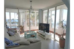 ein Wohnzimmer mit Couch und Flachbildfernseher in der Unterkunft Spacious house in Roquetas de Mar, 140 m², shared pool in Roquetas de Mar