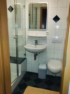 uma casa de banho com um lavatório e um WC em Gasthaus Felbermaier em Lampertshofen