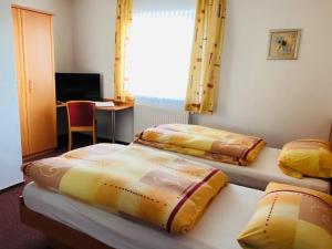 two beds in a room with a desk at Gasthaus Felbermaier in Lampertshofen