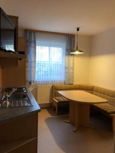 uma cozinha com uma mesa, uma mesa e um sofá em Gasthaus Felbermaier em Lampertshofen