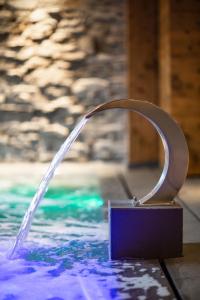 a fountain in a pool with water coming out of it at Hôtel Champs Fleuris Morzine in Morzine