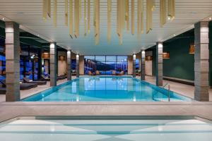 a large swimming pool in a hotel with chandeliers at Hotel Sport Klosters in Klosters