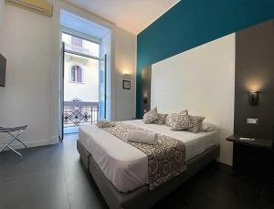 une chambre avec un grand lit et une grande fenêtre dans l'établissement FALERON Santa Lucia, à Naples