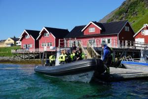 people on a boat in a body of water at Sarnes Seaside Cabins in Honningsvåg