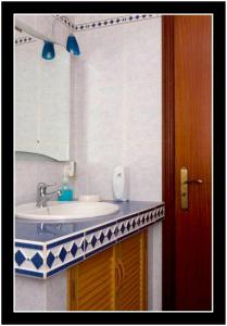 ein Bad mit einem Waschbecken und einem Spiegel in der Unterkunft One bedroom appartement with sea view terrace and wifi at Lajes Do Pico in Lajes do Pico