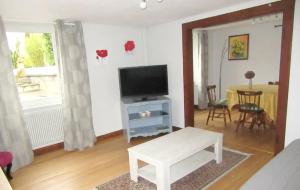 un salon avec une télévision et une table dans l'établissement Maison charmante à Gottenhouse + Jardin, à Gottenhouse