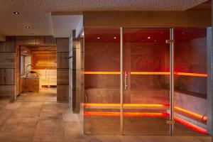 bagno con porta in vetro in camera di Hotel Sonnenspitze a Ehrwald