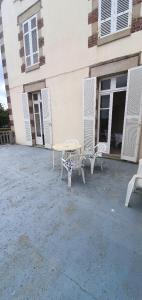 uma mesa e duas cadeiras em frente a um edifício em Appartement d'une chambre a Saint quay portrieux a 100 m de la plage avec vue sur la mer et terrasse amenagee em Saint-Quay-Portrieux