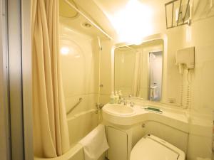 
a bathroom with a toilet, sink and shower at Hotel Route-Inn Jouetsu in Joetsu
