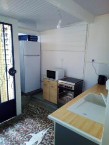 a small kitchen with a stove and a refrigerator at Maison confortable avec jardin à Basse-Terre + Parking inclus in Basse-Terre