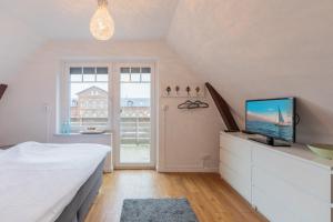 a bedroom with a bed and a tv on a dresser at Charmantes Stadthaus in Husum