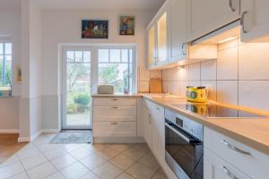 a kitchen with white cabinets and a counter top at Charmantes Stadthaus in Husum