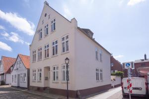 a white building on the side of a street at Apartmenthaus Theodor Storm Dämmerstunde in Husum