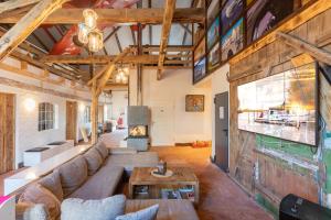 an open living room with a couch and a fireplace at Lodge an der Eider in Friedrichsgraben