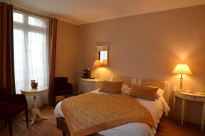 a hotel room with a bed and a window at Villa Augeval Hôtel de charme & Spa in Deauville