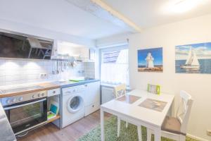 a kitchen with a washing machine and a table at Apartmenthaus Tönning Kleine Kajüte in Tönning