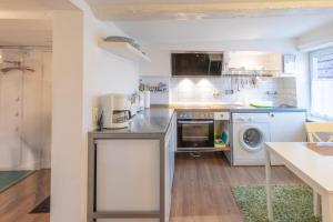 a kitchen with a washer and dryer at Apartmenthaus Tönning Kleine Kajüte in Tönning +3 photos