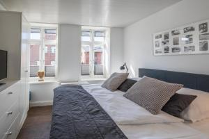 1 dormitorio con 1 cama grande y 2 ventanas en Apartmenthaus Theodor Storm Meeresstrand, en Husum