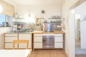 テニングにあるApartmenthaus Tönning Strandmuschelのシンクとコンロのあるキッチン +3枚の写真