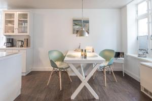 cocina con mesa blanca y 2 sillas en Apartmenthaus Theodor Storm Meeresstrand, en Husum