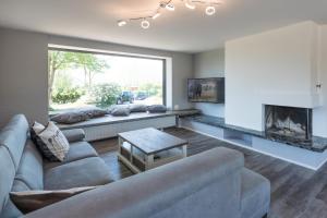 a living room with a couch and a fireplace at Schobüller Austernfischer in Halebüll