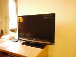 TV de pantalla plana en la parte superior de un escritorio en Hotel Route-Inn Naha Asahibashi Eki Higashi, en Naha